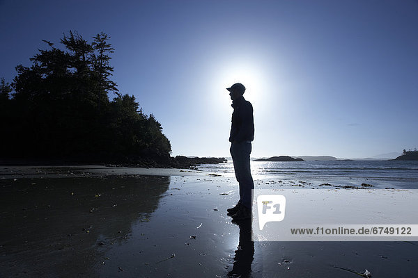 Man Standing on Beach in Tofino  BC  Canada