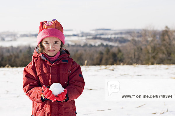 Girl Standing in Field with Snowball