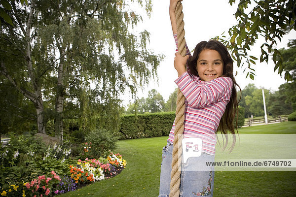 Young Girl Swinging on Rope