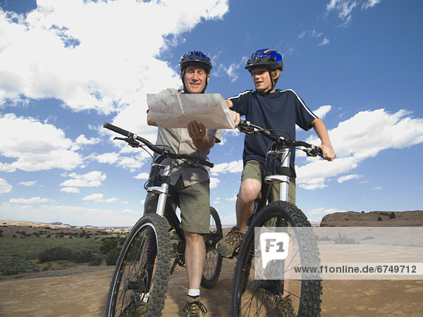 Father and son on mountain bikes with map