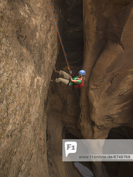 Woman canyon rappelling