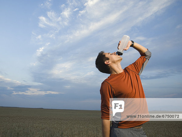 Man in athletic gear drinking water