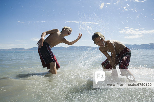 Brothers splashing in lake  Utah  United States