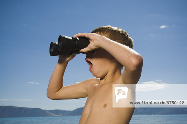 Boy looking through binoculars  Utah  United States