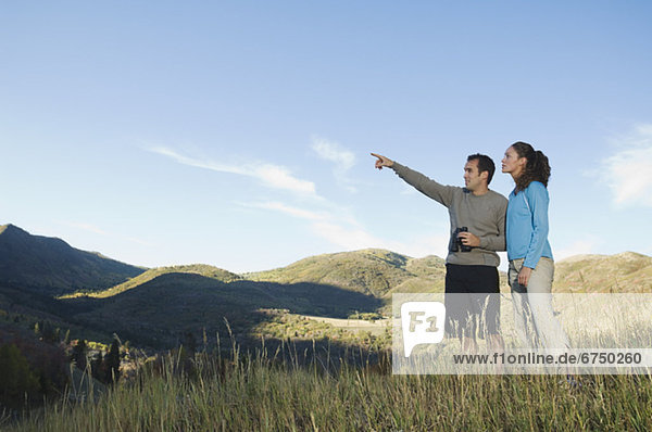 Couple holding binoculars and pointing  Utah  United States