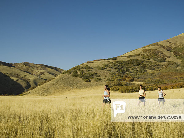 Group of people running in field  Utah  United States
