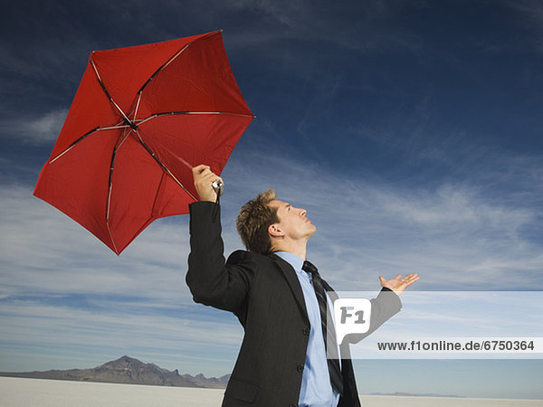 Businessman holding umbrella  Salt Flats  Utah  United States