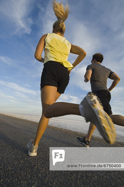 Couple running on road  Utah  United States