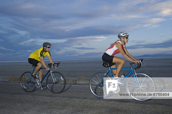 Couple cycling on road  Utah  United States