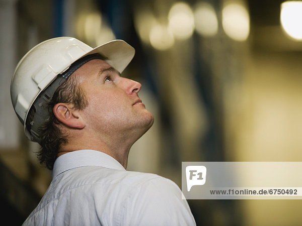 Man wearing hard hat and looking up