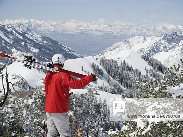 Man holding skis on shoulder