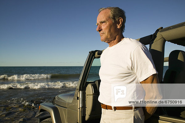 Man Looking at Ocean from Shoreline