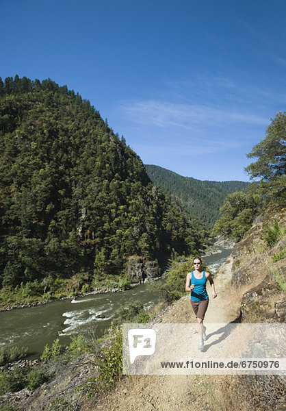 Woman running on riverside trail
