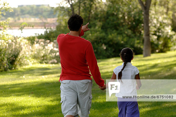 Father and Daughter Walking in Park