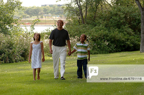 Father and Children Walking in Park