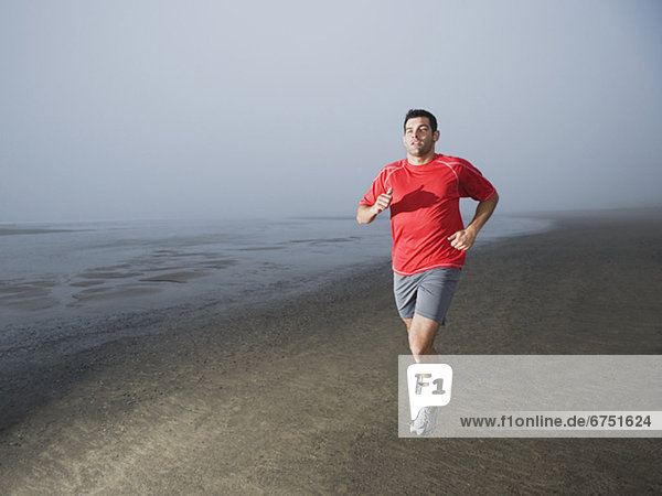Man jogging on foggy beach