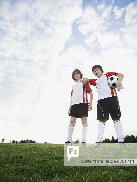 Portrait of boys in soccer uniforms holding ball