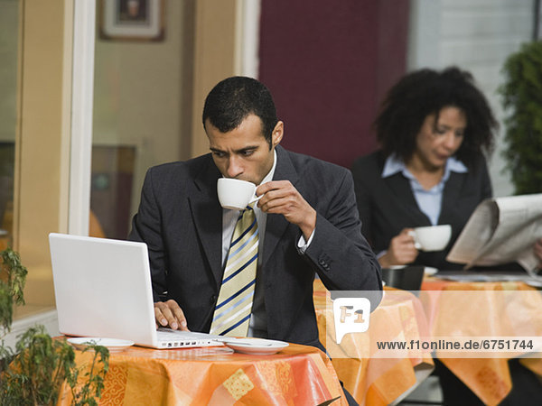 Businessman looking at laptop at outdoor cafe
