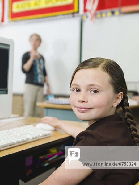 Elementary student sitting at desk in classroom