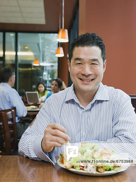 Man eating salad in restaurant