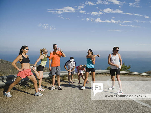 Runners stretching on a road in Malibu