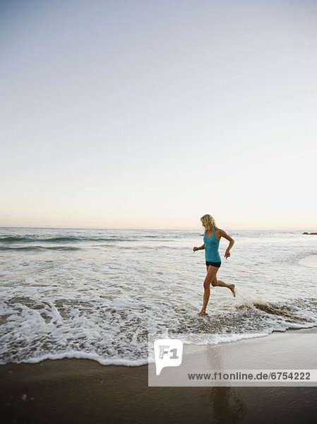 Portrait of woman running on beach
