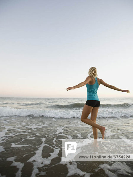 Portrait of woman running on beach