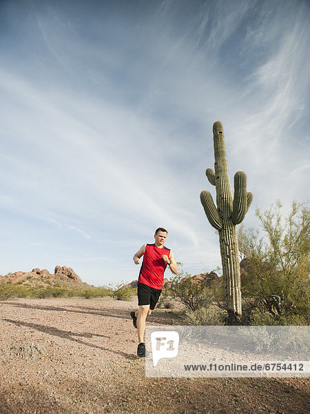 USA  Arizona  Phoenix  Mid adult man jogging on desert