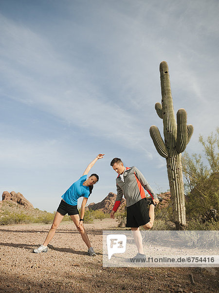 USA  Arizona  Phoenix  Mid adult man and young woman exercising on desert