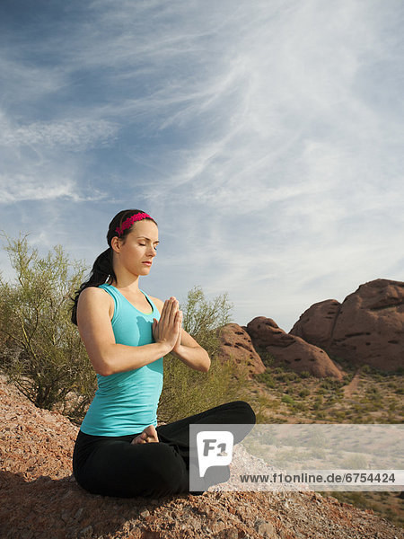 USA  Arizona  Phoenix  Young woman practicing yoga on desert