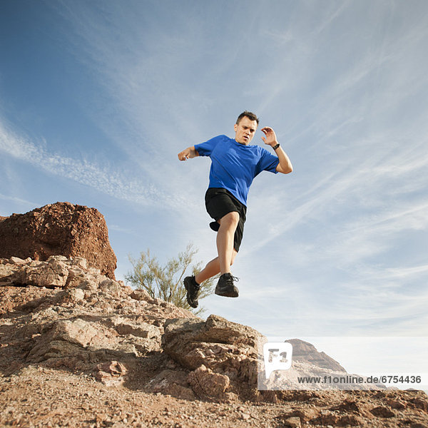 USA  Arizona  Phoenix  Mid adult man jogging on desert