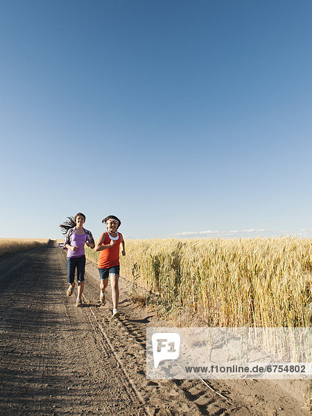 Girls (12-13  10-11) running along dirt road