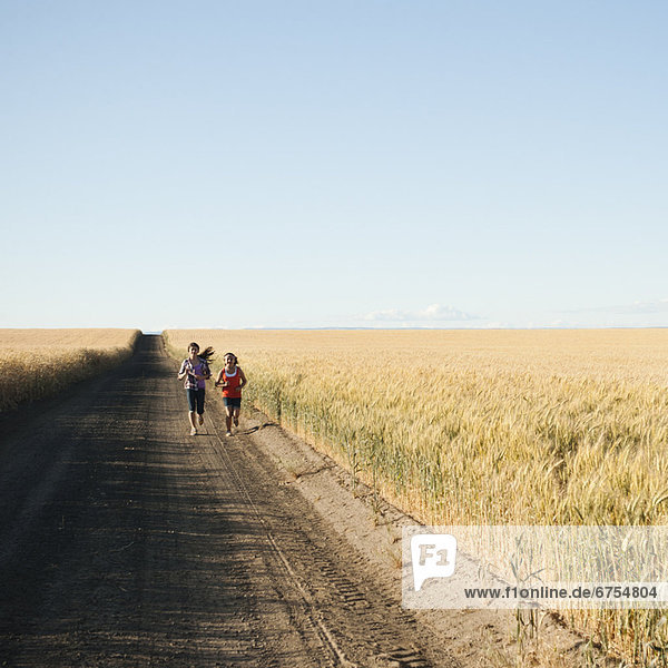 Girls (12-13  10-11) running along dirt road