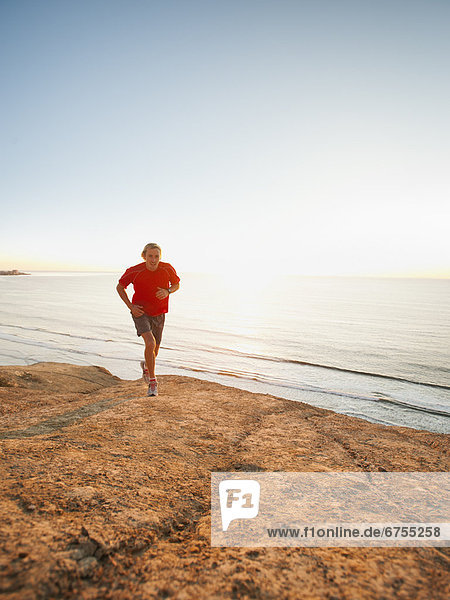 USA  California  San Diego  Man jogging along sea coast