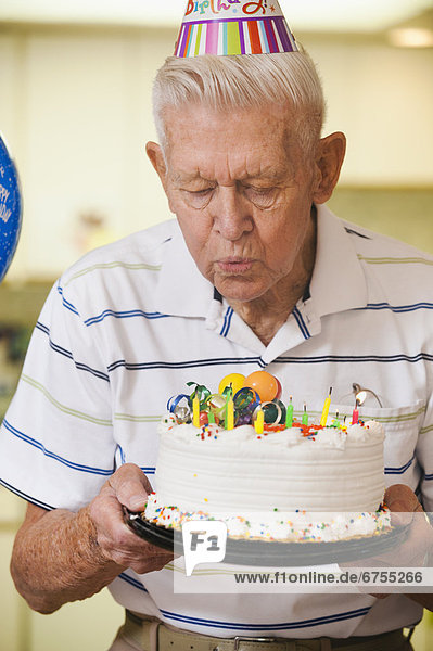 Senior  Senioren  Mann  blasen  bläst  blasend  Geburtstag  Kuchen  Kerze