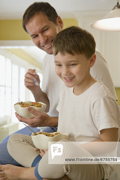 Menschlicher Vater  Sohn  Küche  essen  essend  isst  Frühstück  Tresen