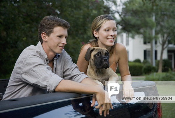 Couple and dog in back of truck