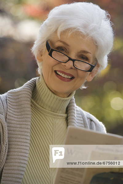 Außenaufnahme  Senior  Senioren  Portrait  Frau  Zeitung  freie Natur  vorlesen