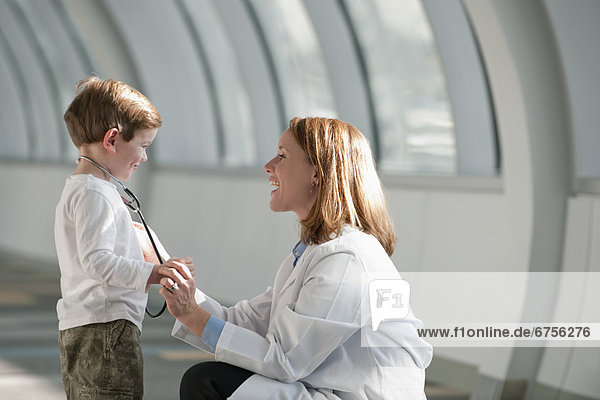 USA  Virginia  Virginia Beach  female doctor talking to boy (6-7) in corridor