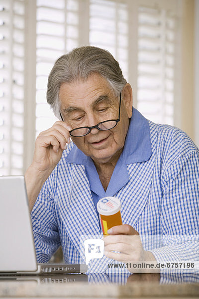 Senior man reading medication bottle