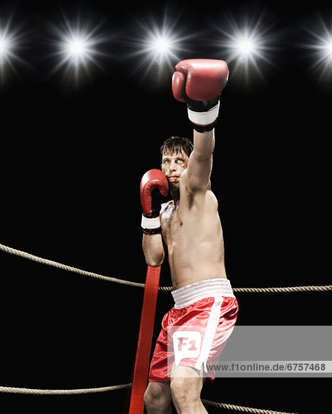 Boxer extending arm in boxing ring
