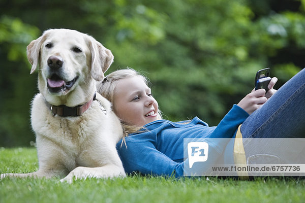 Girl resting on dog in park
