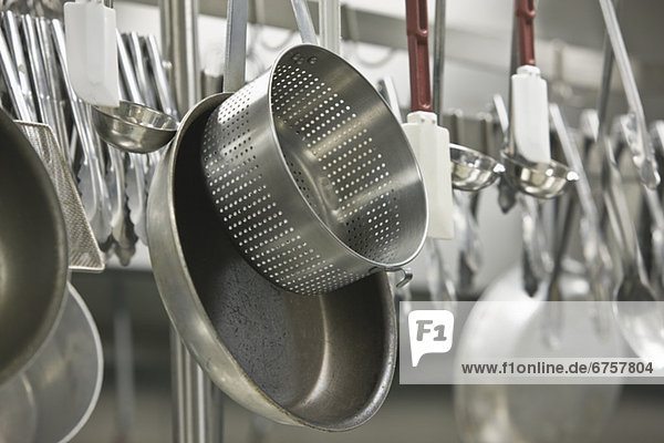 Pots and cooking utensils hanging from rack