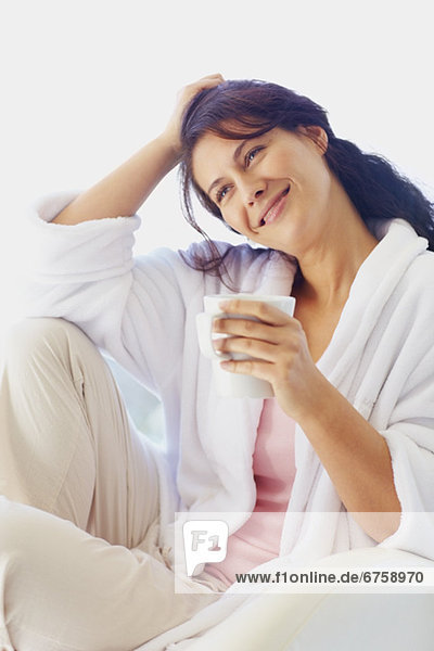 Woman in bathrobe drinking coffee