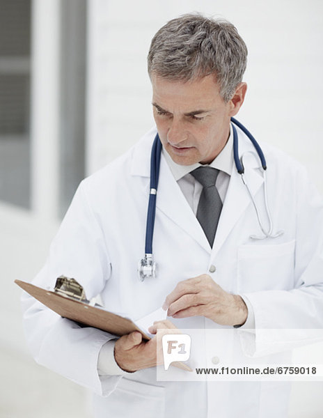 Doctor looking at clipboard