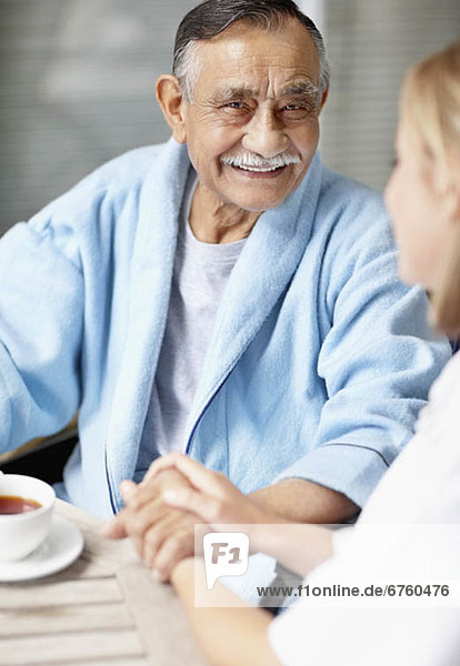 Nurse and senior patient sitting at table