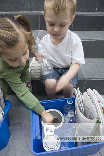 Children placing Household Recycling in a Blue Box  Vancouver  British Columbia