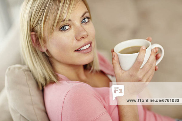 Portrait of young blonde woman drinking coffee