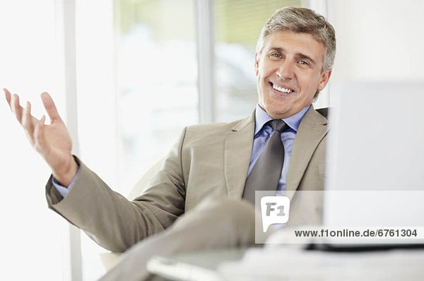 Portrait of cheerful businessman with laptop