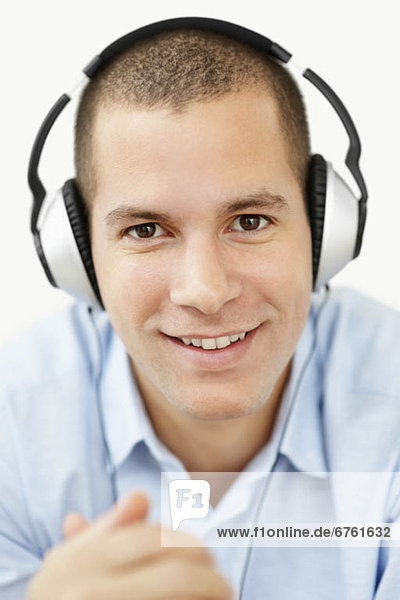 South Africa  Young man wearing earphones and looking at camera  studio shot
